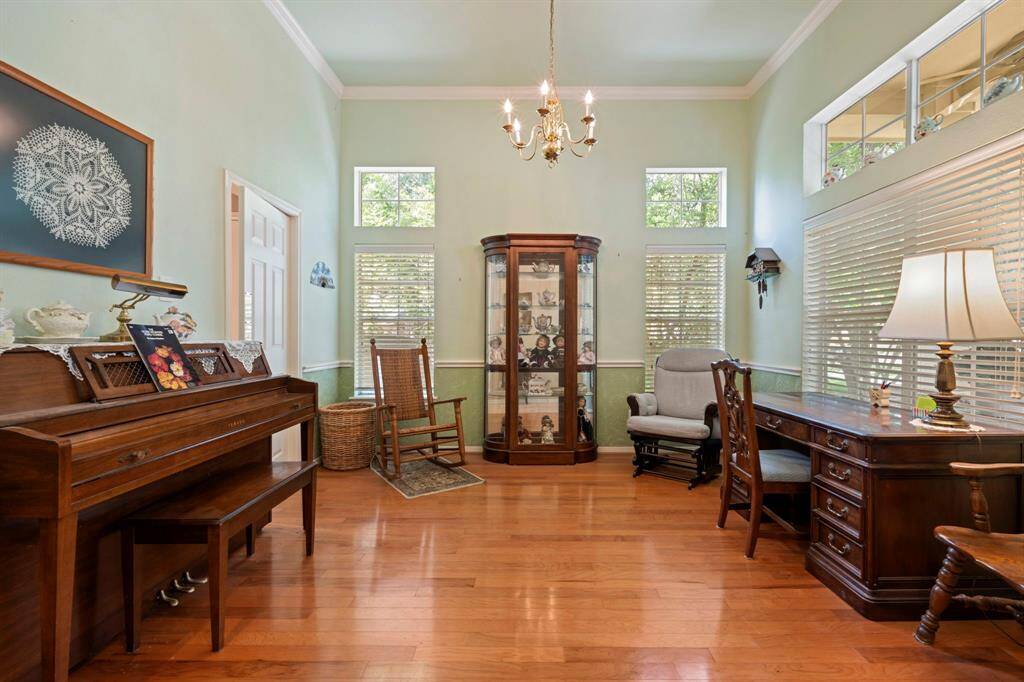 this bright and inviting formal dining room boasts high ceilings, crown moulding, elegant lighting & featuring hardwood floors.  This room has large windows for ample natural light and can also be ideal for a study,  a music room or reading space.