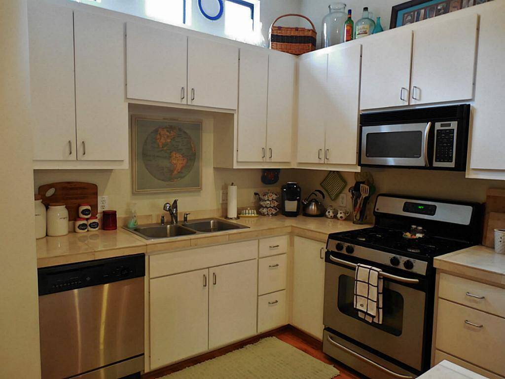 Light and bright contemporary kitchen with marble counter tops and stainless steel appliances