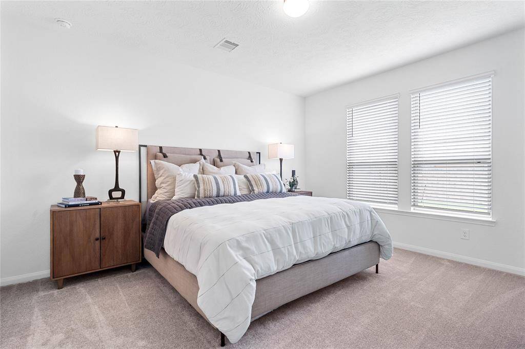 Come and unwind after a long day in this magnificent primary suite! This spacious room features plush carpet, warm paint, high ceilings and large windows with privacy blinds.