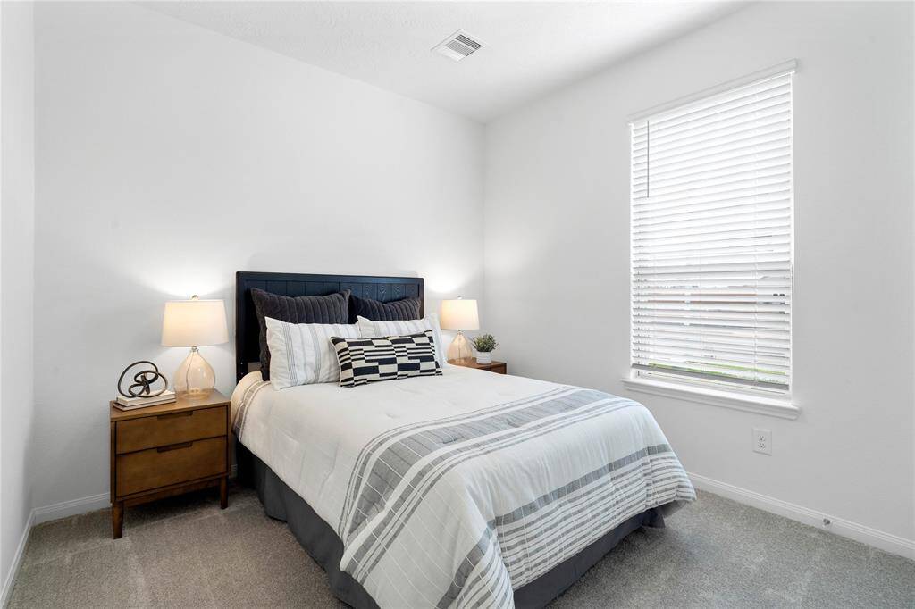 Secondary bedroom features plush carpet, neutral paint, lighting, large window with privacy blinds and ample sized closet space.