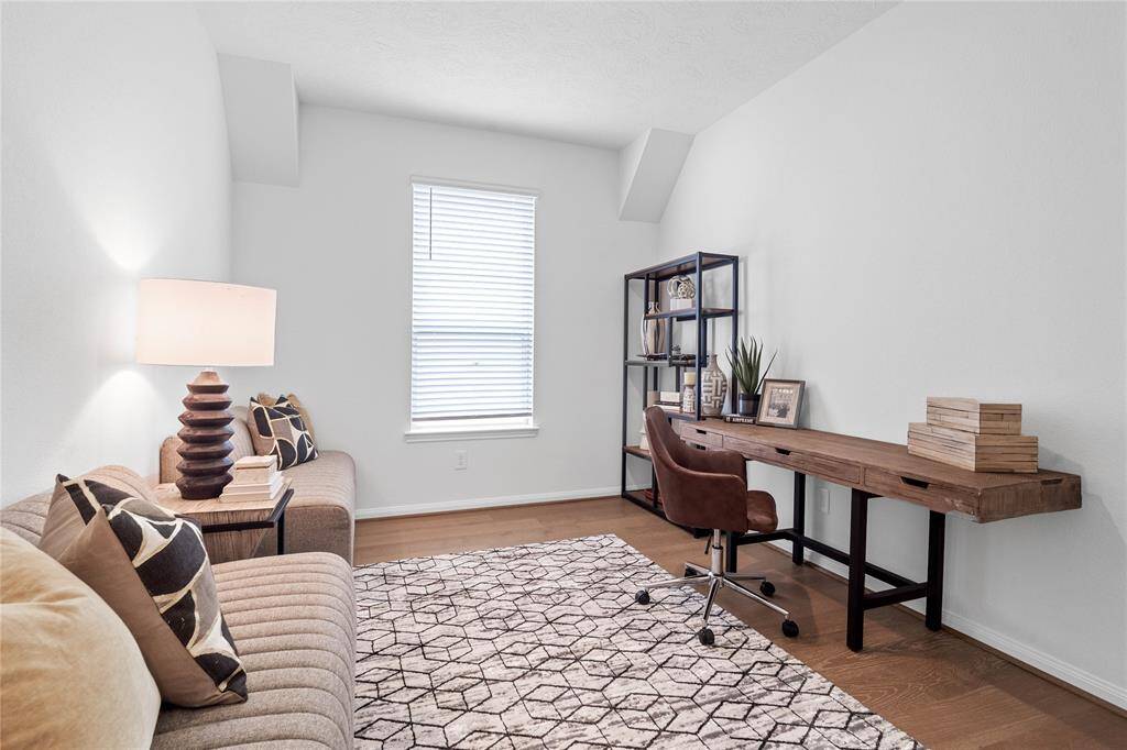 This handsome den features engineered wood flooring, high ceilings, large window with privacy blinds and neutral paint.