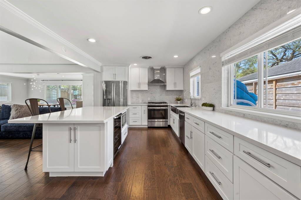 The stunning kitchen has stainless steel appliances with a gas range. The quartz countertops are easy to maintain and provide lots of prep space in this kitchen.
