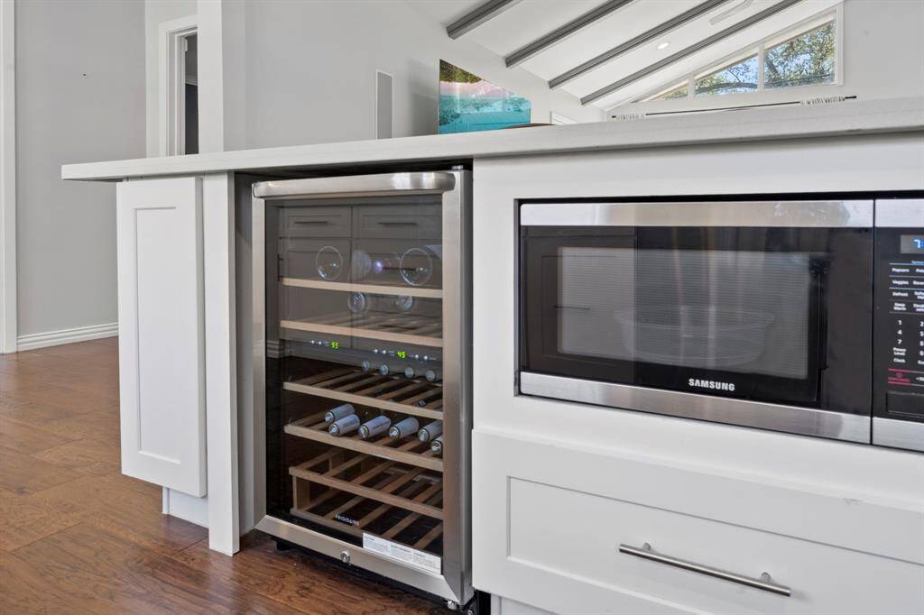 A nice perspective of the wine cooler and microwave.