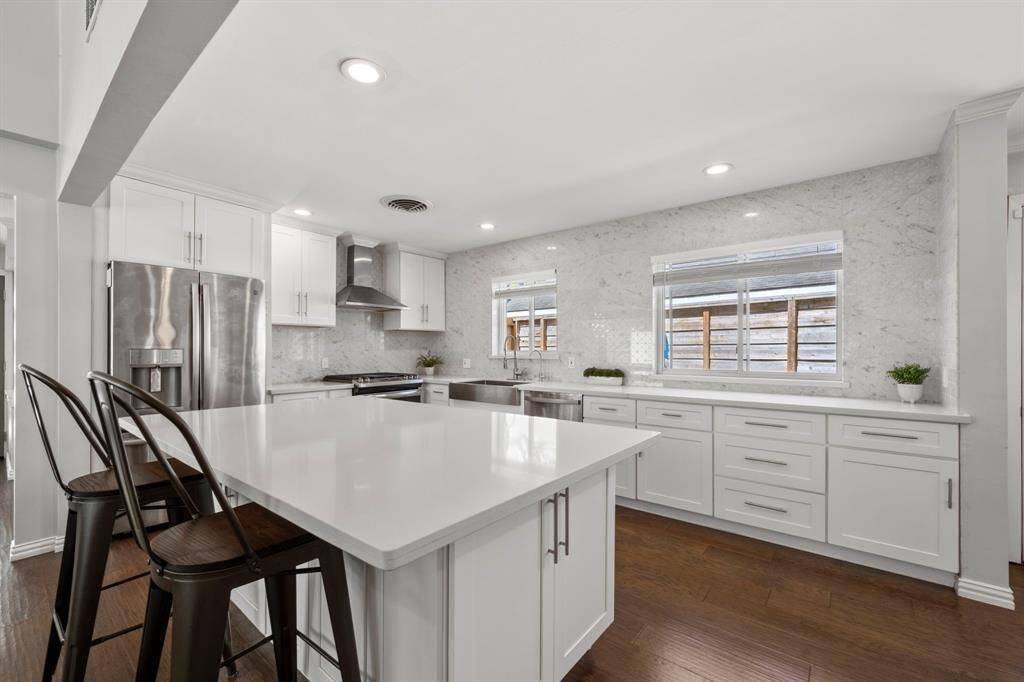 Abundant windows fill the kitchen with natural light, enhancing the warm and inviting atmosphere. Custom cabinetry offers a thoughtful mix of drawers and cabinets for a seamless, clutter-free look.
