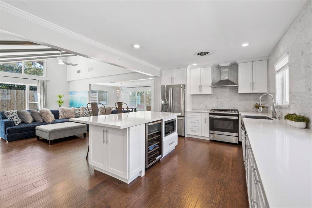 Kitchen highlights include a built-in microwave and wine cooler seamlessly integrated into the island, maximizing space and functionality. The island also doubles as a stylish breakfast bar—perfect for casual dining or entertaining.