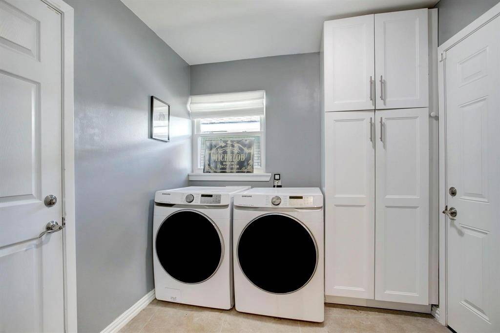The spacious laundry room features built-in storage and convenient access to both the garage and backyard—ideal for effortlessly dropping wet pool towels or swimsuits straight into the wash.