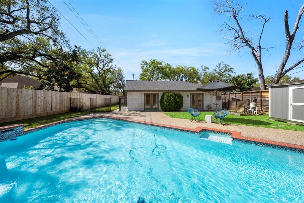 The sparkling pool is the centerpiece of a generously sized backyard, with ample green space and room to entertain. An ideal setting for summer gatherings and poolside fun.
