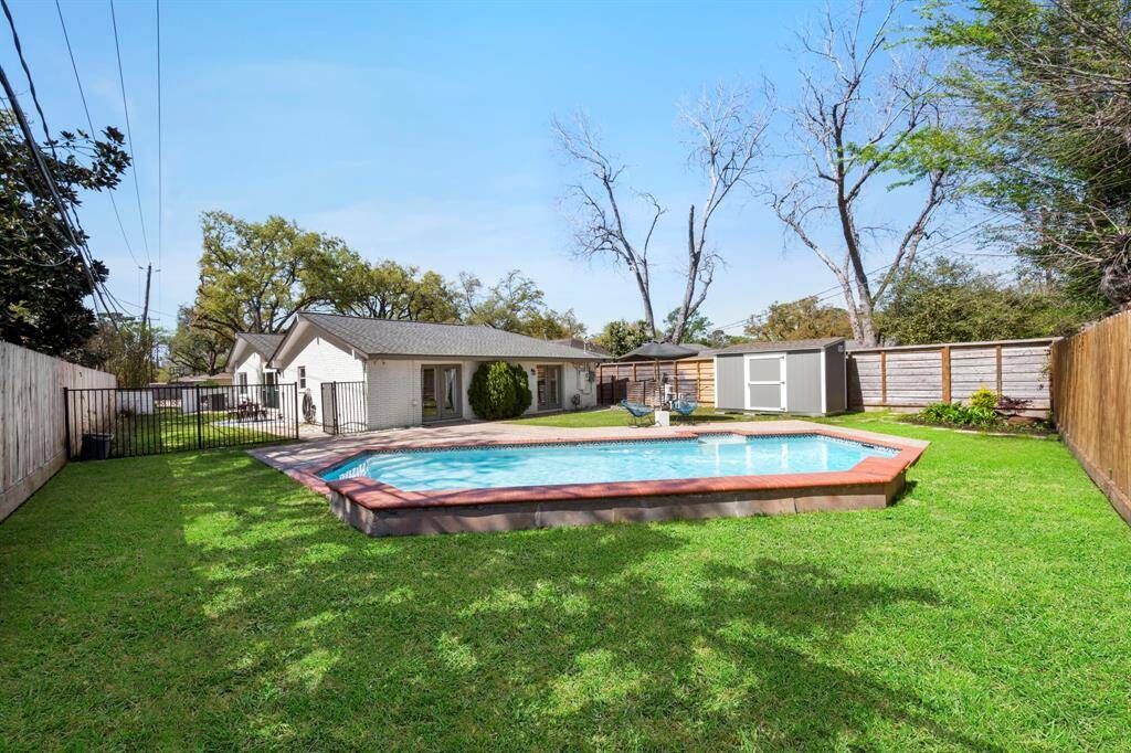 A view toward the back of the home reveals a beautifully landscaped yard and a crystal-clear pool—ready for you to dive in and enjoy the perfect outdoor escape.