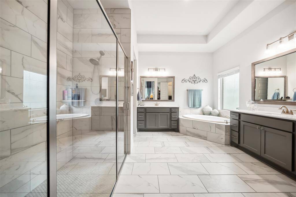 The primary bathroom has a separate shower and a soaking tub and his and hers walk in closets