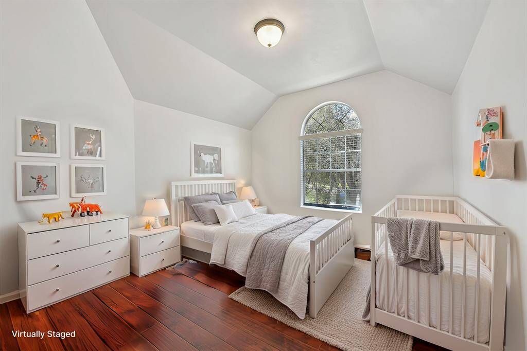Inviting hallway leading to bedrooms 2 and 3, featuring elegant wood flooring and stylish archways.