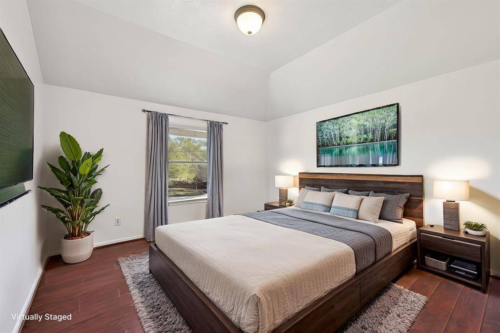 Charming and spacious secondary bedroom with vaulted ceilings and abundant natural light, beautifully illustrated through virtual staging.