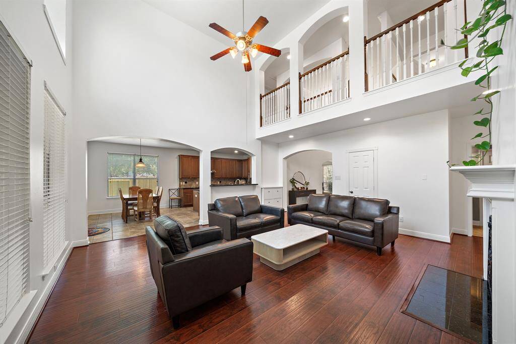 Bright and airy living room with soaring ceilings, large windows, and elegant hardwood floors, perfect for relaxation and entertaining.