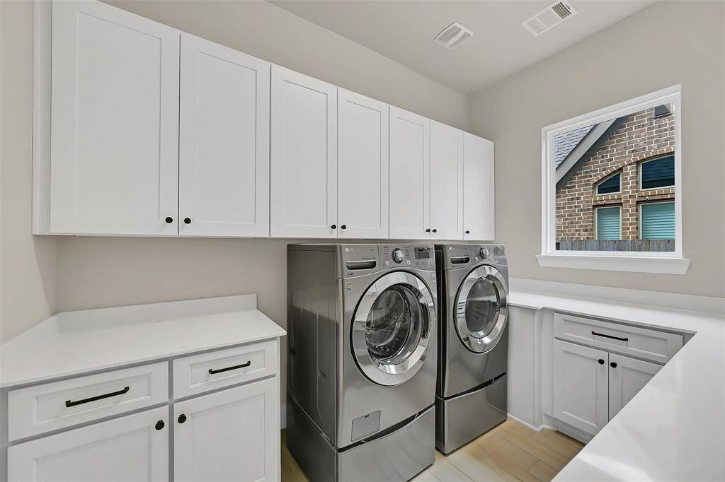 With an Enormous Wrap-A-Round Counter Area, Laundry is a Breeze! Copious Storage in Additional Cabinetry on BOTH Sides of the Room Makes Finding Your Cleaning Supplies So Easy! On the Right Side (Not Shown in This Photo) There is Additional Space for a Second Refrigerator!!!! The Like New, High-End Washer and Dryer Stay with the Property - Lucky You!