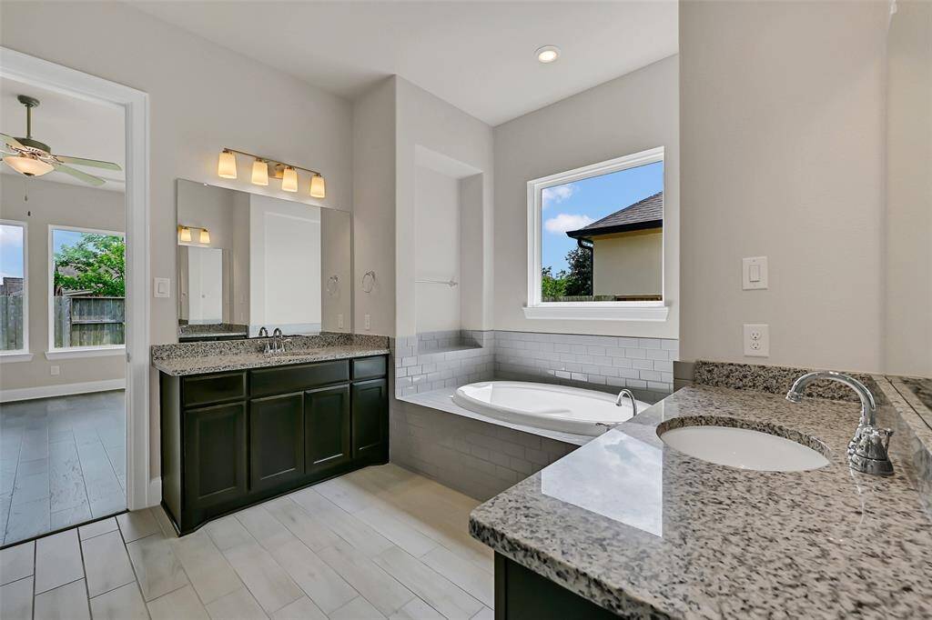 A Perspective of the Primary Bathroom Featuring the Separated Double Sinks and Luxurious Garden Tub!