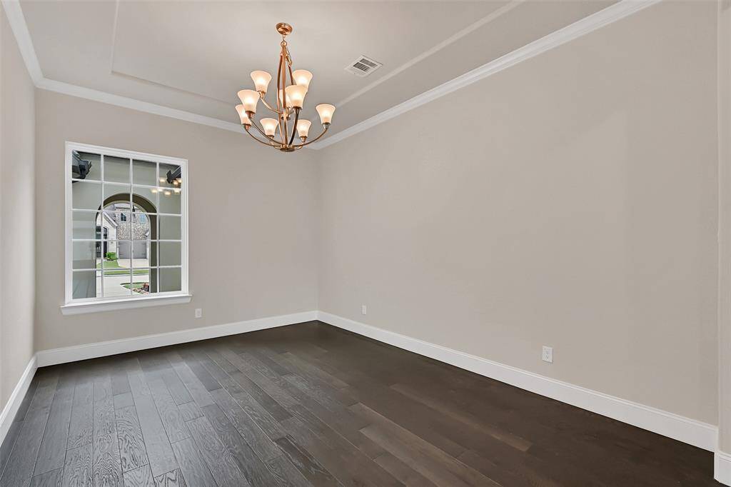Located at the Front of the Home, and Overlooking the Private Courtyard, the Dining Room Features Wonderful Crown Molding and Tray Ceiling Accents!