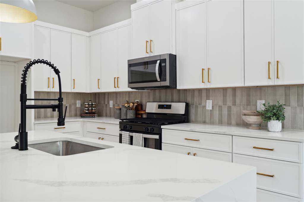 Sleek thin shaker style design in the cabinetry offers ample storage with soft-close drawers and stylish hardware.
