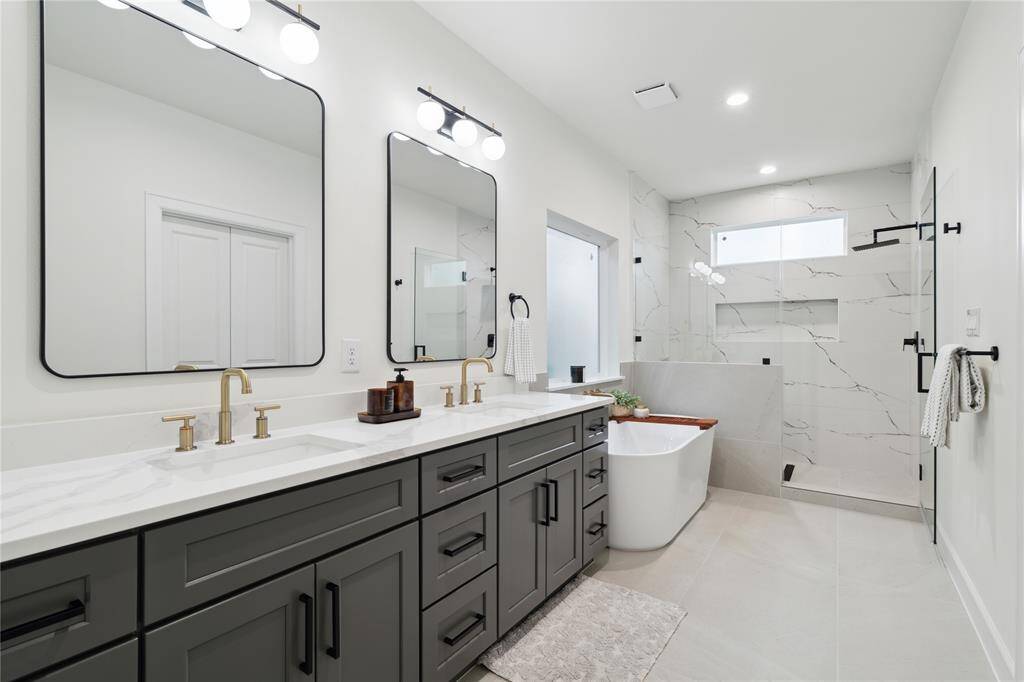 Luxurious bathroom, featuring expansive quartz countertops, his-and-hers sinks, ample drawer storage, and generous cabinet space. Designed for ultimate comfort and organization.