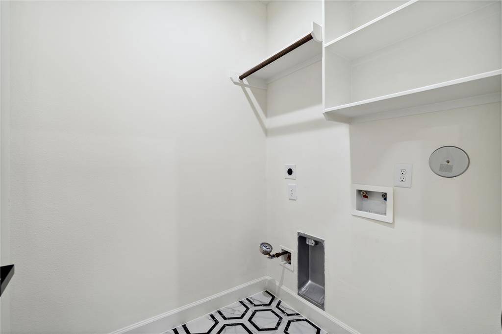 Discover a functional utility room equipped with shelves and ample storage, ideal for organizing essentials and maximizing efficiency