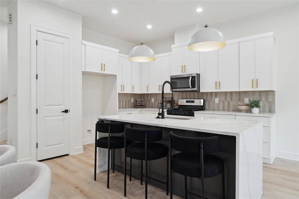 An oversized 7-foot quartz waterfall island commands attention in this culinary haven, paired with a stunning backsplash that adds a touch of glamour to every meal. The perfect blend of style and functionality for the heart of your home.