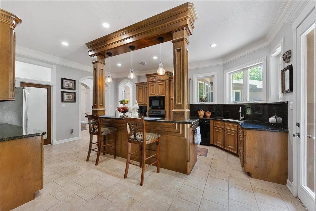 Kitchen with breakfast bar area! 2 sinks, huge pantry, 2 ovens (One gas and one electric) + microwave that are all convection. plus warming drawer! Kitchen window overlooks backyard and deck area!