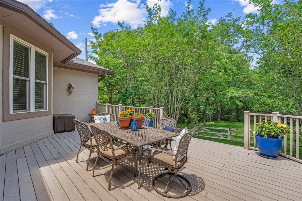 Exterior decking overlooks the peaceful backyard.  Walk across creek on bridges. Deck overlooks one of the pastures!