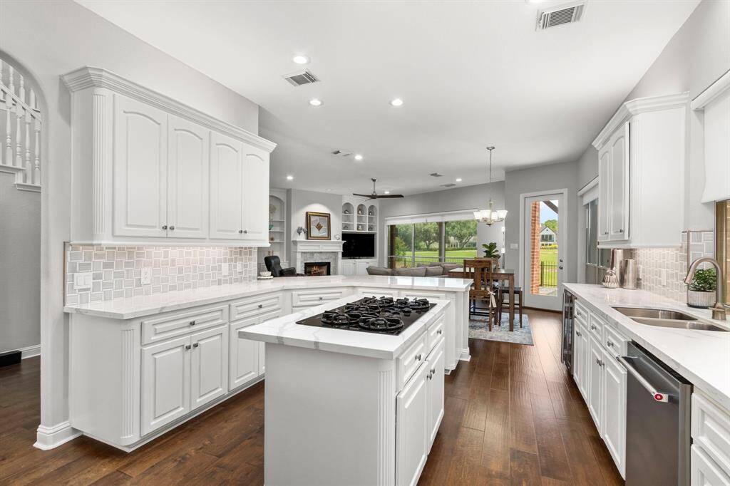 Gorgeous chef's kitchen with center island boasts abundant custom raised-panel cabinetry, gorgeous quartz countertops and a beautiful coordinating backsplash.