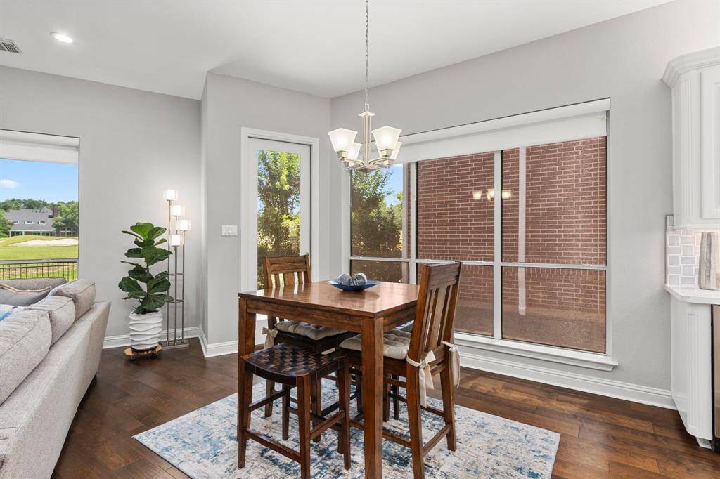 The breakfast area is spacious and surrounded by windows. The window on the right offers views of the private side yard. The glass door opens to the beautiful patio area and backyard, while the family room's window on the left offers views of the gorgeous golf course.