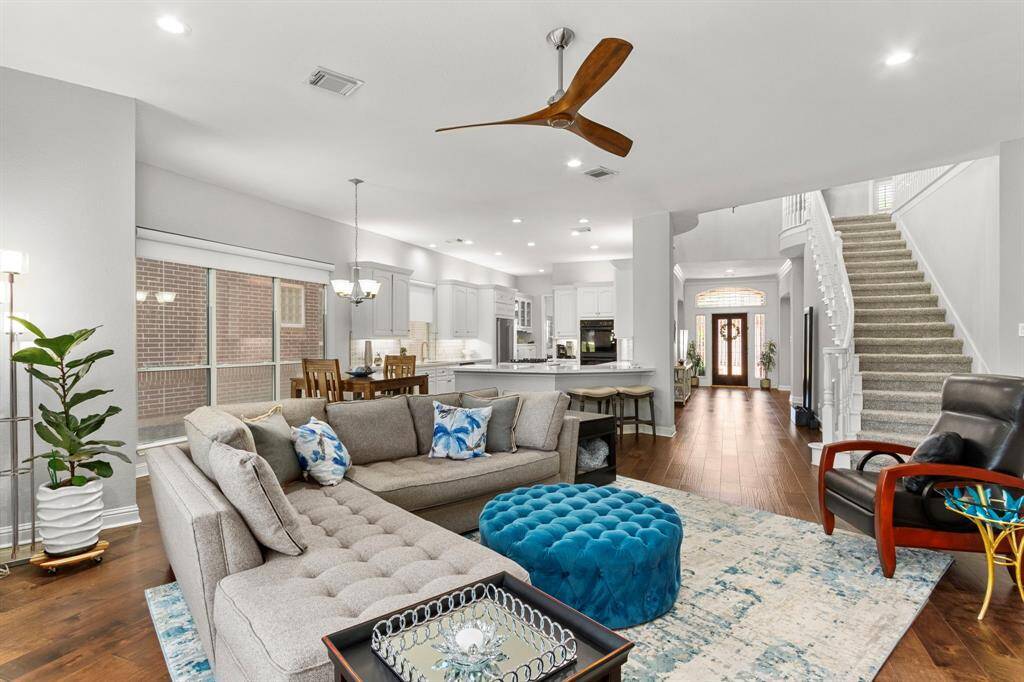 Another look at the handsome family room looking back past the stairway to the main entry and into the breakfast room and kitchen. This home's floor plan was designed and built for easy living and wonderful entertaining possibilities.