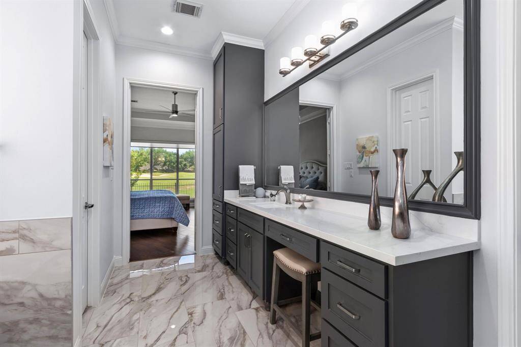 A look back from the ensuite bath, past the abundant cabinetry into the primary bedroom.