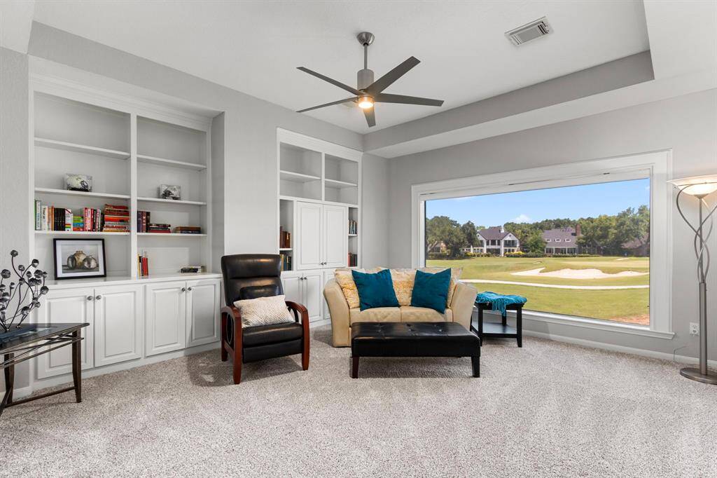 The gameroom offers plush neutral carpet. The room is large with tray ceilings, designer ceiling fan with lighting with built-in cabinetry to create a functional and very useable space.  This room offers a huge picture window with expansive views of the golf course.