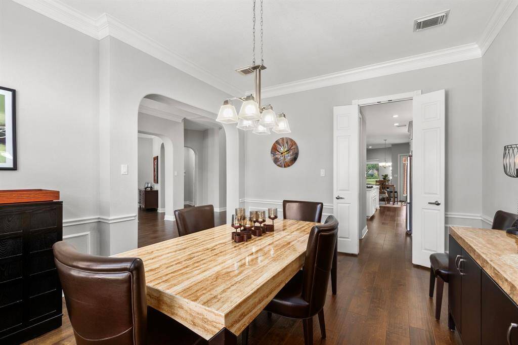 A look from the dining room back into the front entry hallway and through double doors through the butler's pantry to the kitchen.