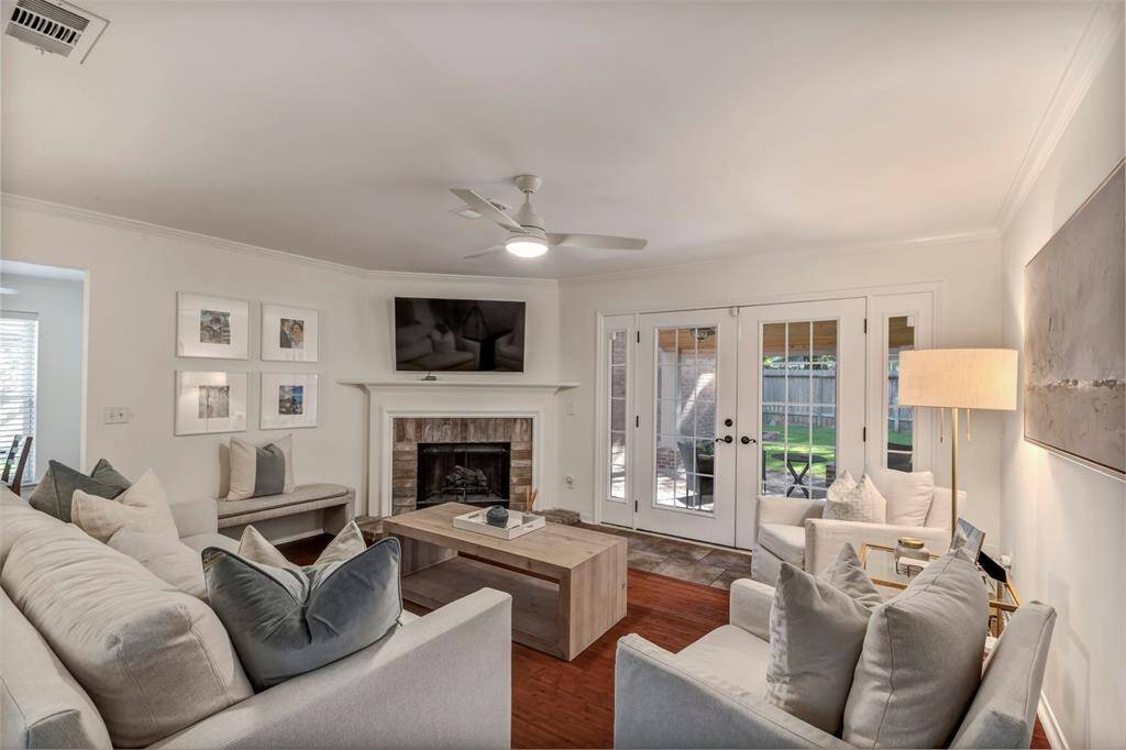 Living room with gas fireplace and views of backyard