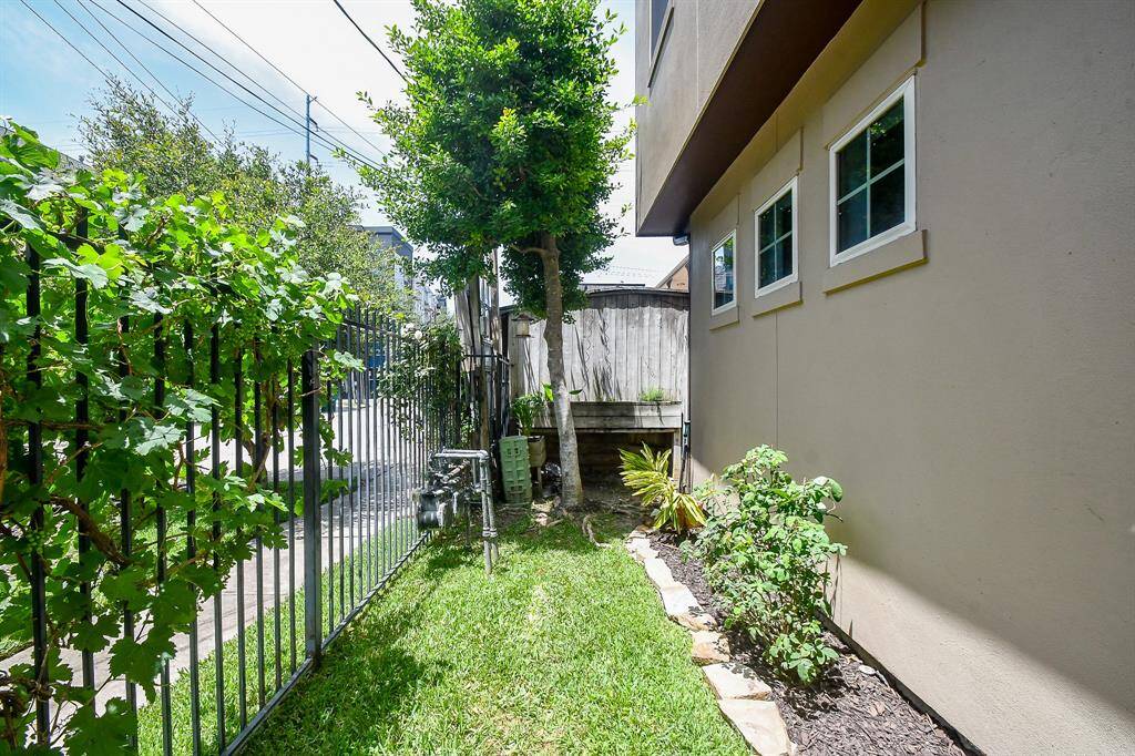Garden area continues around the side of home with sprinkler system.