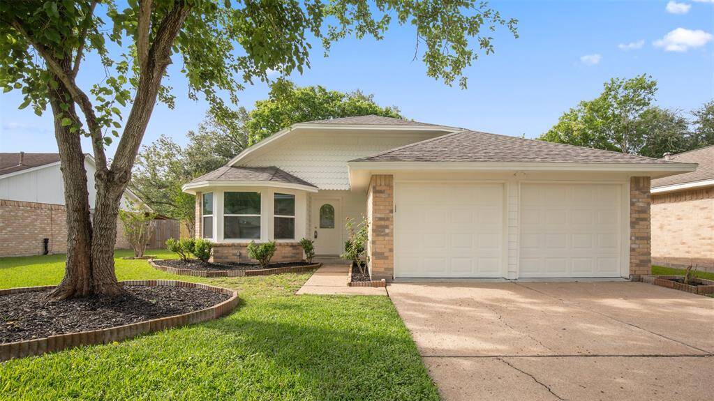 Charming single-story home with a welcoming exterior is highlighted by a well-maintained lawn and mature trees. Features include a double garage and a cozy curb appeal.