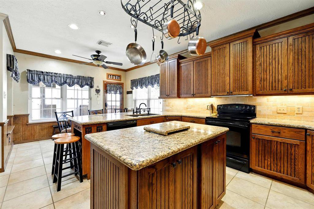 This stylish kitchen features a central island and a breakfast bar, which are perfect for casual dining and conversation. Custom cabinetry includes a built-in wine rack, adding both function and flair.