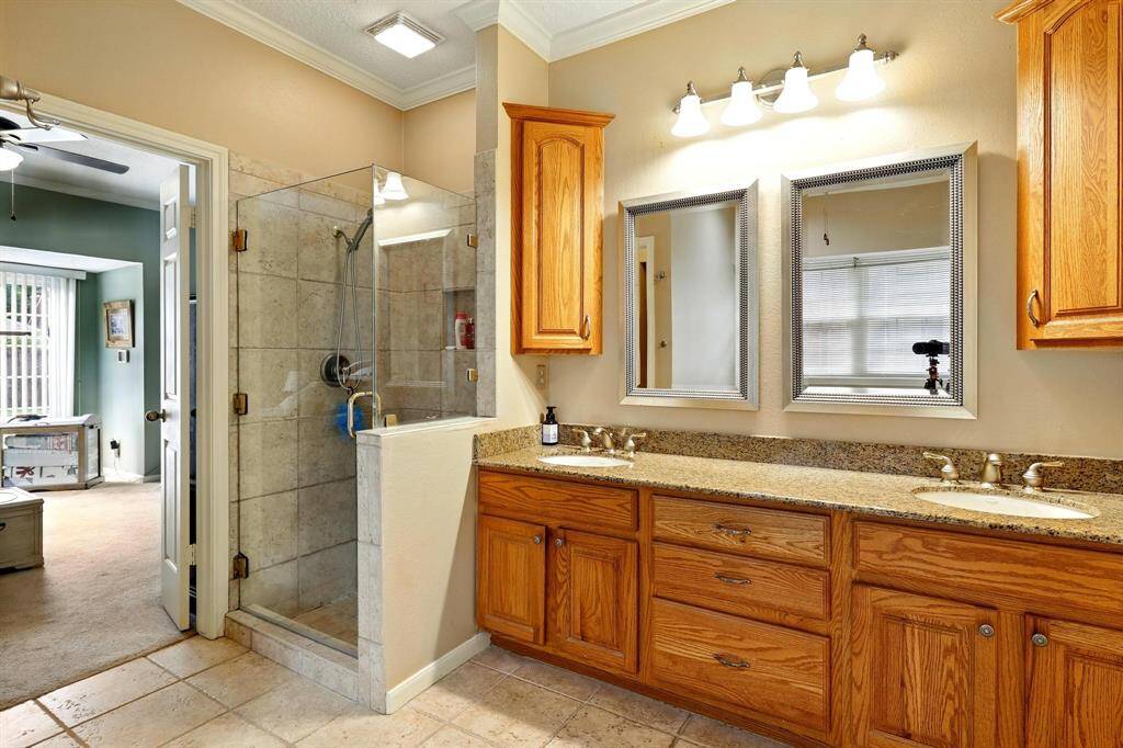The primary ensuite features dual sinks, frameless glass shower, and a relaxing whirlpool tub for a spa-like experience. A private water closet and two walk-in closets provide comfort and convenience.