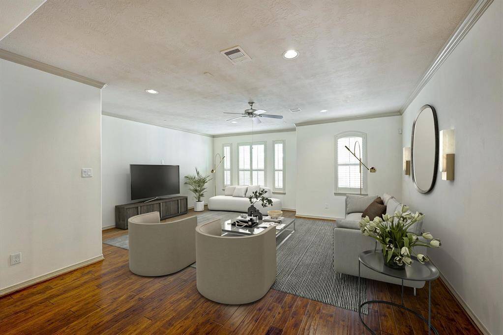 Open living floor plan. The space features rich hardwood flooring that adds warmth and elegance, complemented by a neutral color palette on the walls and ceiling.