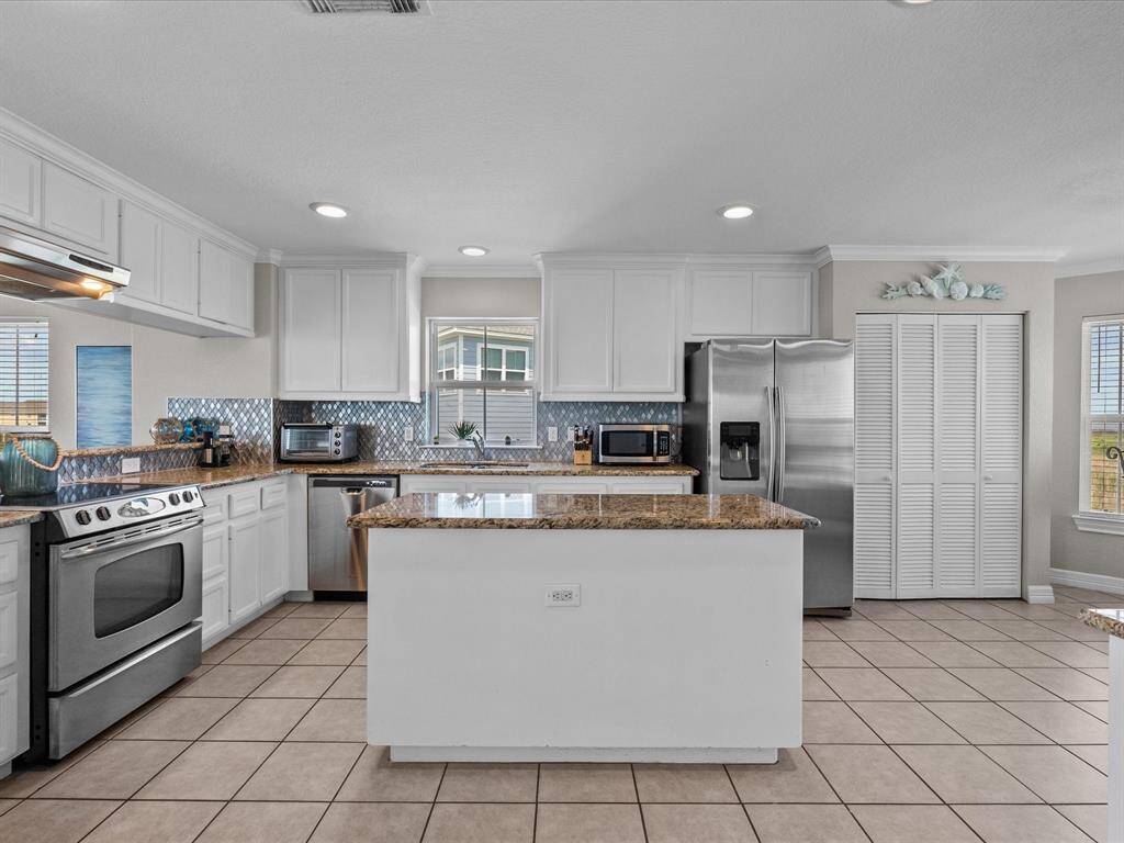 It features a large central island and stainless steel appliances