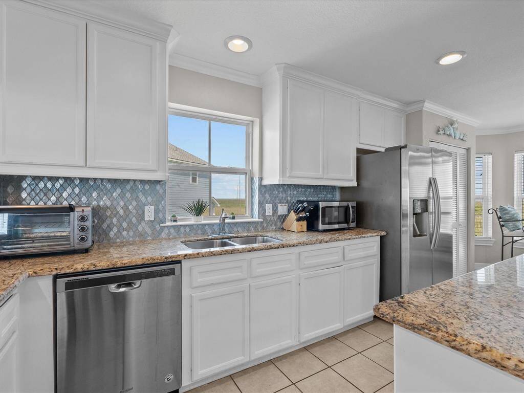 This expansive open-concept kitchen is the heart of the home. Look at that back splash!