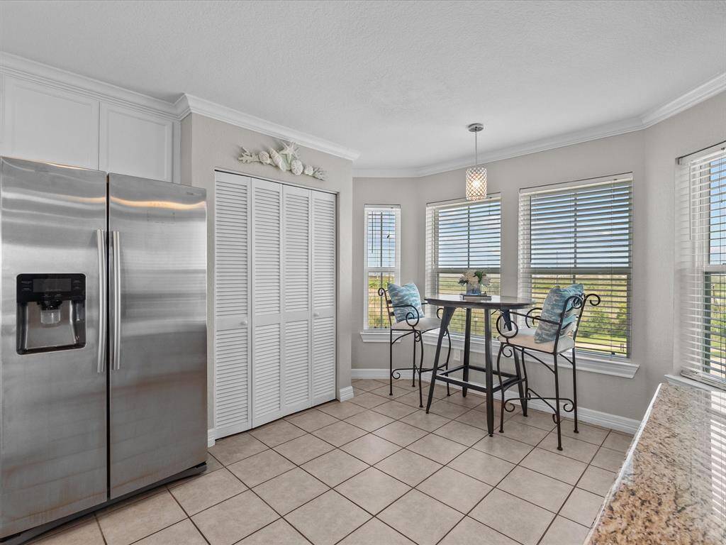 The adjoining kitchen nook, bathed in natural light from large windows.