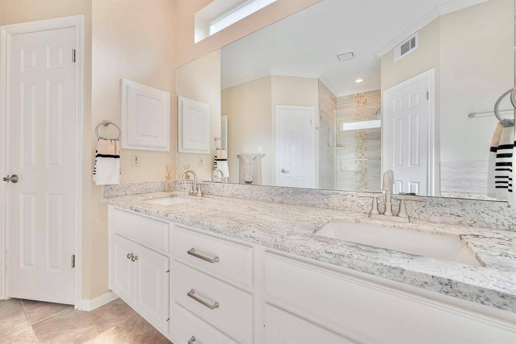 The vanity in the primary bathroom also features granite counter tops and a stand alone shower