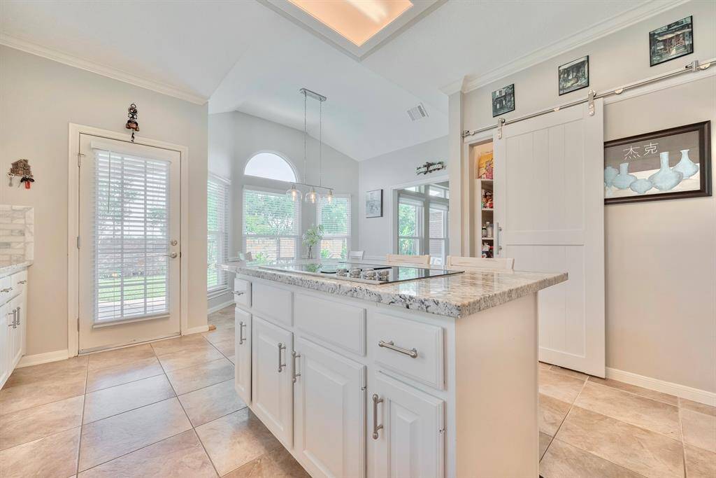 Another view of the kitchen featuring a sliding door to the pantry