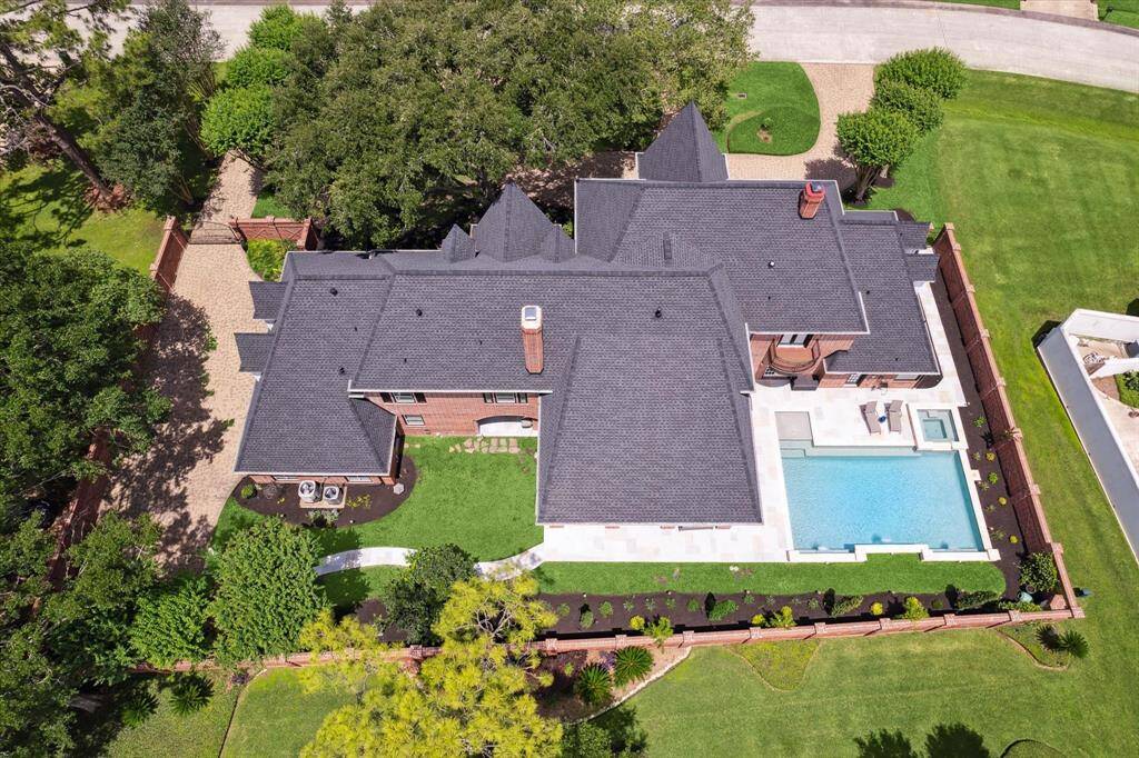 Aerial view captures the grandeur and functionality of the home's outdoor living space—ideal for hosting gatherings or enjoying quiet down time in a serene setting. Meticulous landscaping.