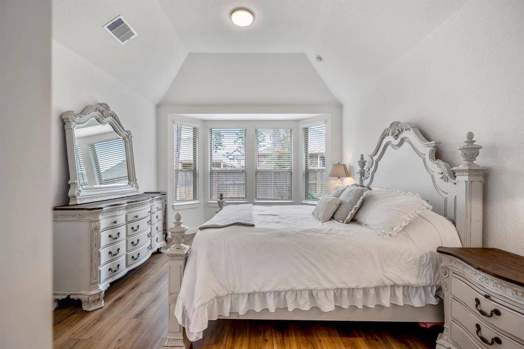 Upon entering the primary suite, you're greeted by vaulted ceilings that add to the room's spacious feel. The bay windows fill the room with natural light, creating a serene and inviting atmosphere. Luxury vinyl plank flooring extends throughout the suite, offering both style and durability. This private retreat is designed for comfort and relaxation.