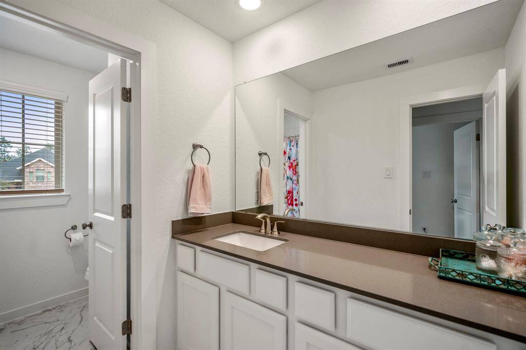This spacious full bathroom features plenty of counter space, offering both style and functionality. The separated tub/shower area and toilet provide added privacy and convenience, making it an ideal layout for shared use. With its large design, the bathroom creates a comfortable and functional space that complements the home’s overall flow.