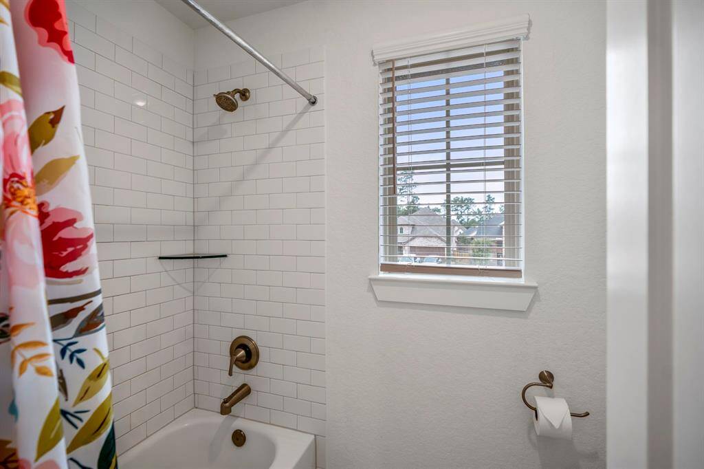 This closer view of the tub/shower and potty area highlights the well-thought-out design, with a separate space for the toilet offering privacy. The window above the tub adds natural light, creating a bright and airy atmosphere in this functional space. The clean lines and spacious feel make it a relaxing and convenient area.