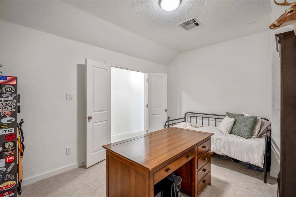 From inside the media room, this view looks back toward the double doors, which lead to the hallway. The room’s layout is ideal for privacy and focus, with ample space for a home theater setup or office. The absence of windows allows for full control over lighting, creating a perfect atmosphere for movie nights or quiet work.