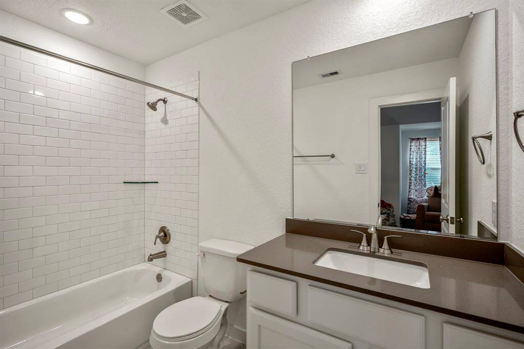 This peek inside the en-suite bath reveals a well-appointed space with modern fixtures and finishes. The bathroom offers both style and function, with ample counter space and a layout that ensures privacy and convenience for the bedroom. The thoughtful design makes this a comfortable and practical addition to the bedroom.