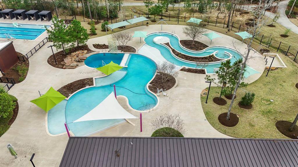 This close-up of the resort-style pool in The Woodlands Hills highlights the inviting and spacious area perfect for relaxation and socializing. Surrounded by lush landscaping and ample lounging space, the pool offers a serene escape for residents. Whether you're swimming, sunbathing, or simply enjoying the atmosphere, the pool area is a key feature of this vibrant community, adding a touch of resort-style living right at home.