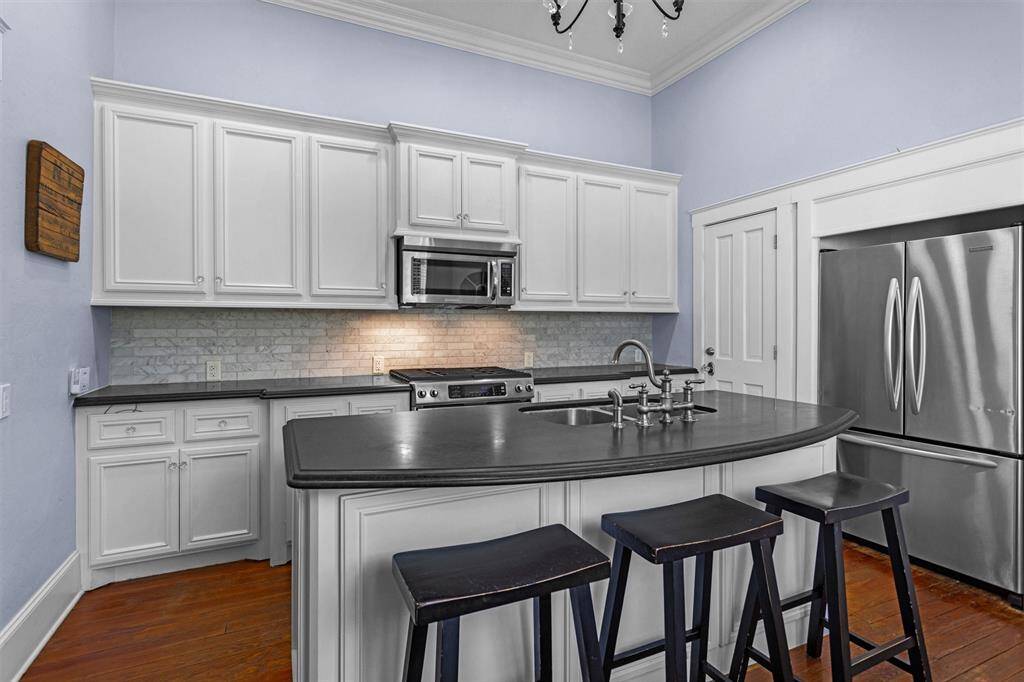 Sold surface counters, stainless steel appliances, and neutral tile backsplash highlight every corner.